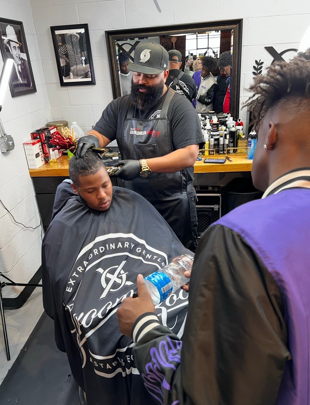 Drew Ervin training a young barber one-on-one at XG Groom Room