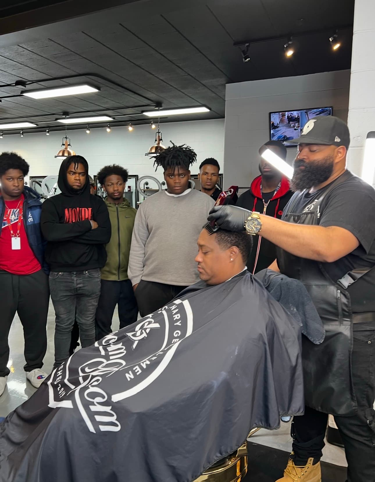 Drew Ervin demonstrating barbering techniques to a group of emerging barbers